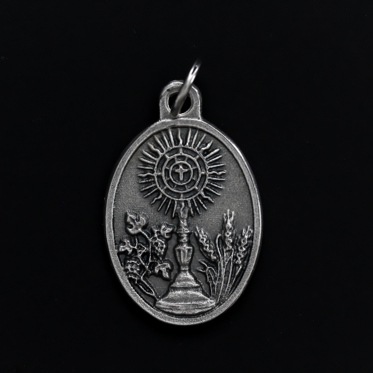 Venerable Carlo Acutis medal that depicts the saint on the front and the symbols of the Eucharist on the back