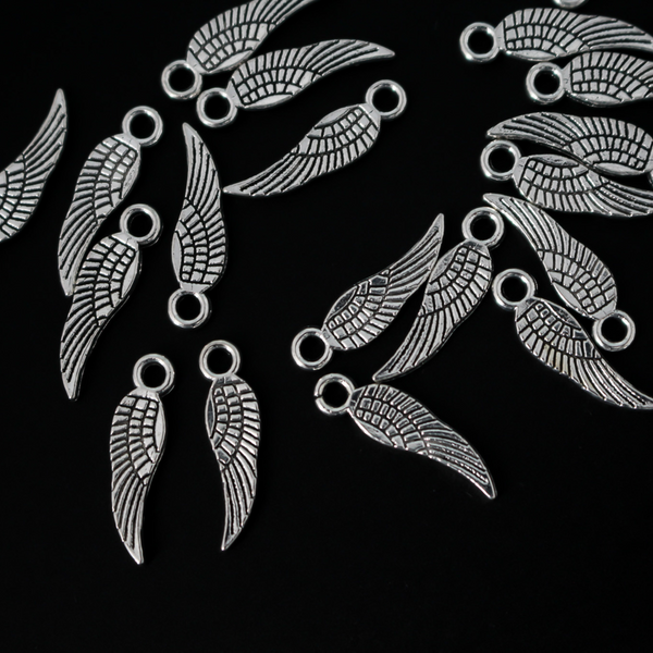 Guardian angel wing charms that are solid and double sided meaning they look the same on the front and back. They are an antiqued silver color.