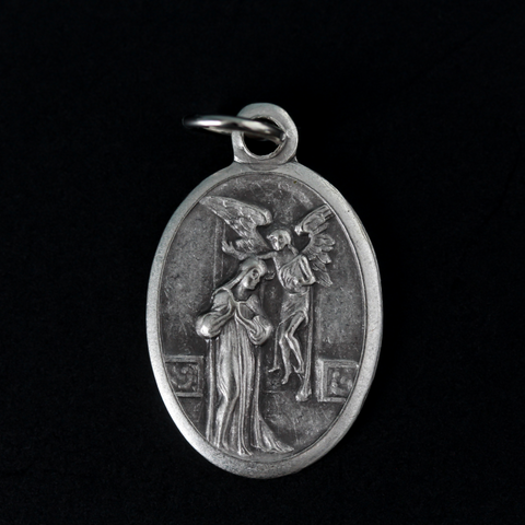 Annunciation of Our Lady medal that depicts the Blessed Virgin Mary with Archangel Gabriel on the front and is marked "Pray For Us" on the back