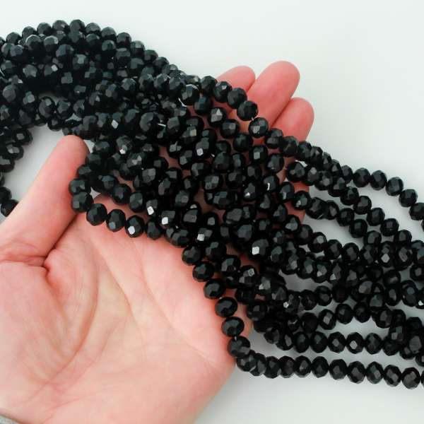 Opaque glass faceted rondelle beads that are solid black in color, 8x6mm