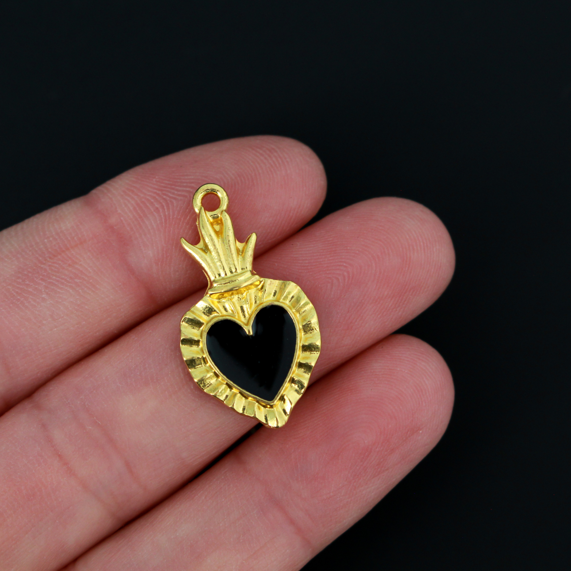 Sacred Heart Ex Voto charms that are a shiny gold color with black enamel detail. 