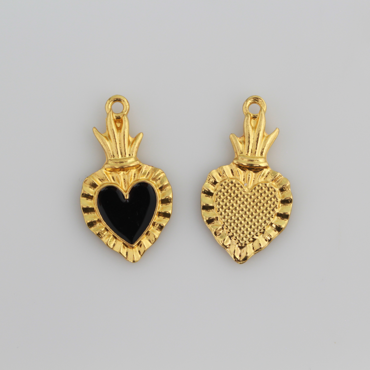 Sacred Heart Ex Voto charms that are a shiny gold color with black enamel detail. 