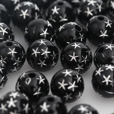 8mm round black opaque beads that have a silver star design etched into them