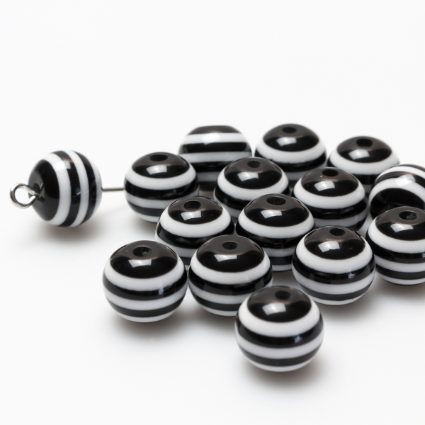Round black and white striped opaque beads that are 10mm in diameter with a 2mm hole size