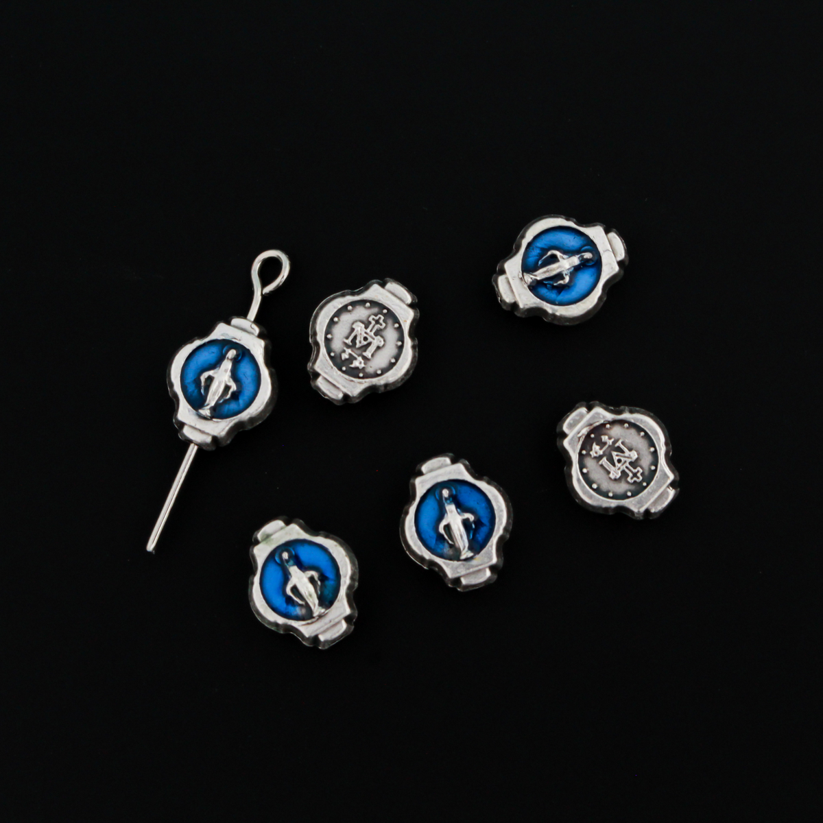Miraculous Medal oval beads that are silver oxidized base metal made in Italy. The front side of the bead has blue enamel detail, the backside does not