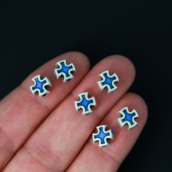 Cross shaped beads that are accented with blue enamel on both sides. 