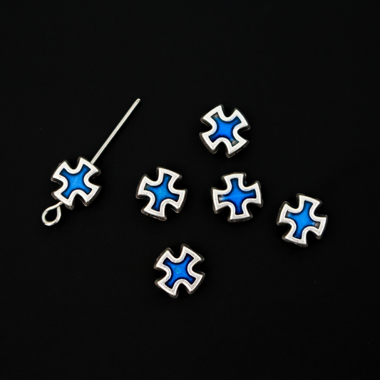 Cross shaped beads that are accented with blue enamel on both sides. 