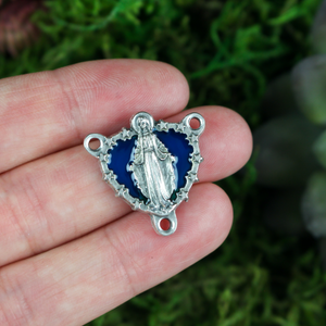 Miraculous Medal rosary centerpiece that depicts Our Lady of Grace on a background of blue enamel with stars around the edges
