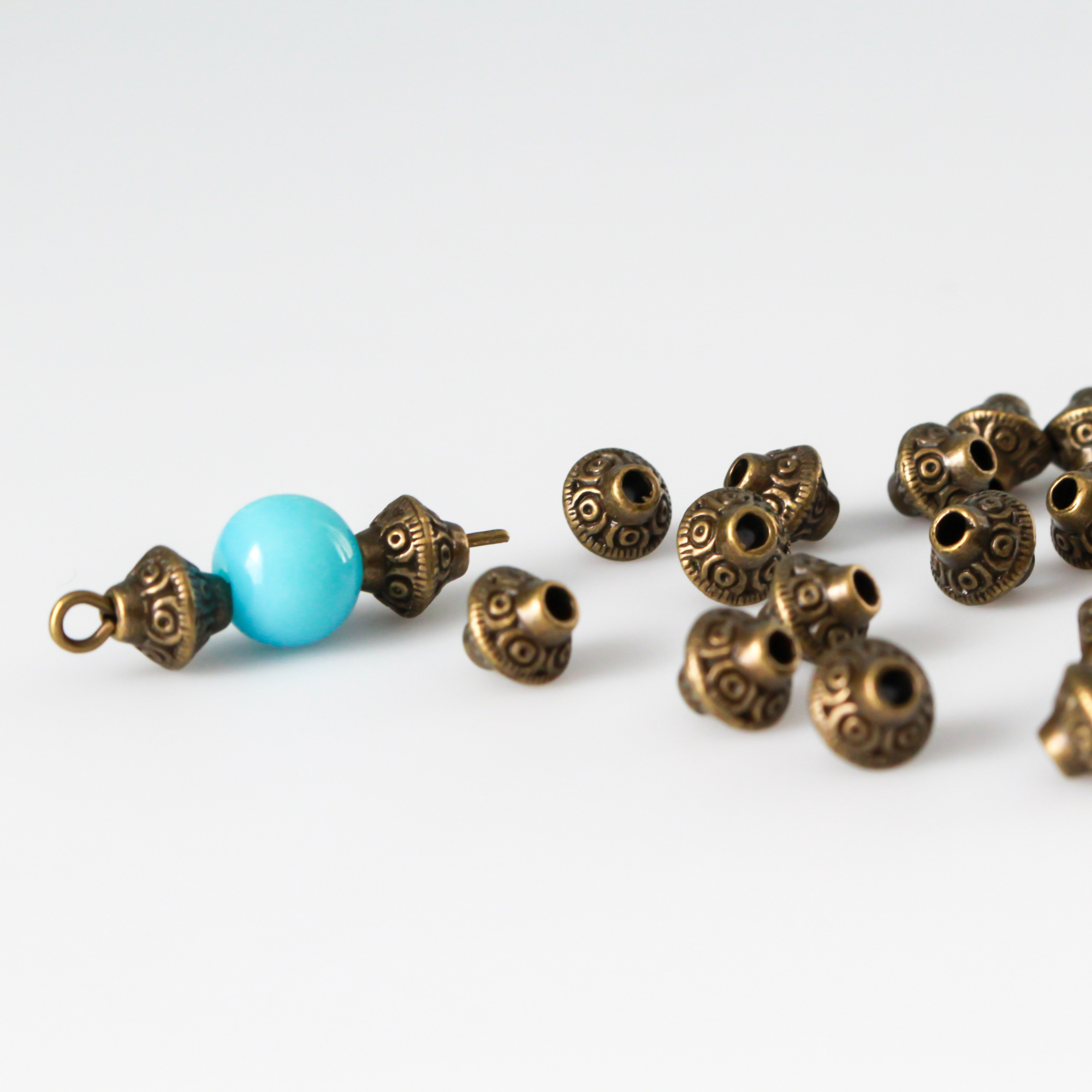 50 metal bicone shaped spacer beads with an antiqued bronze finish and a swirl pattern, 6mm x 6mm