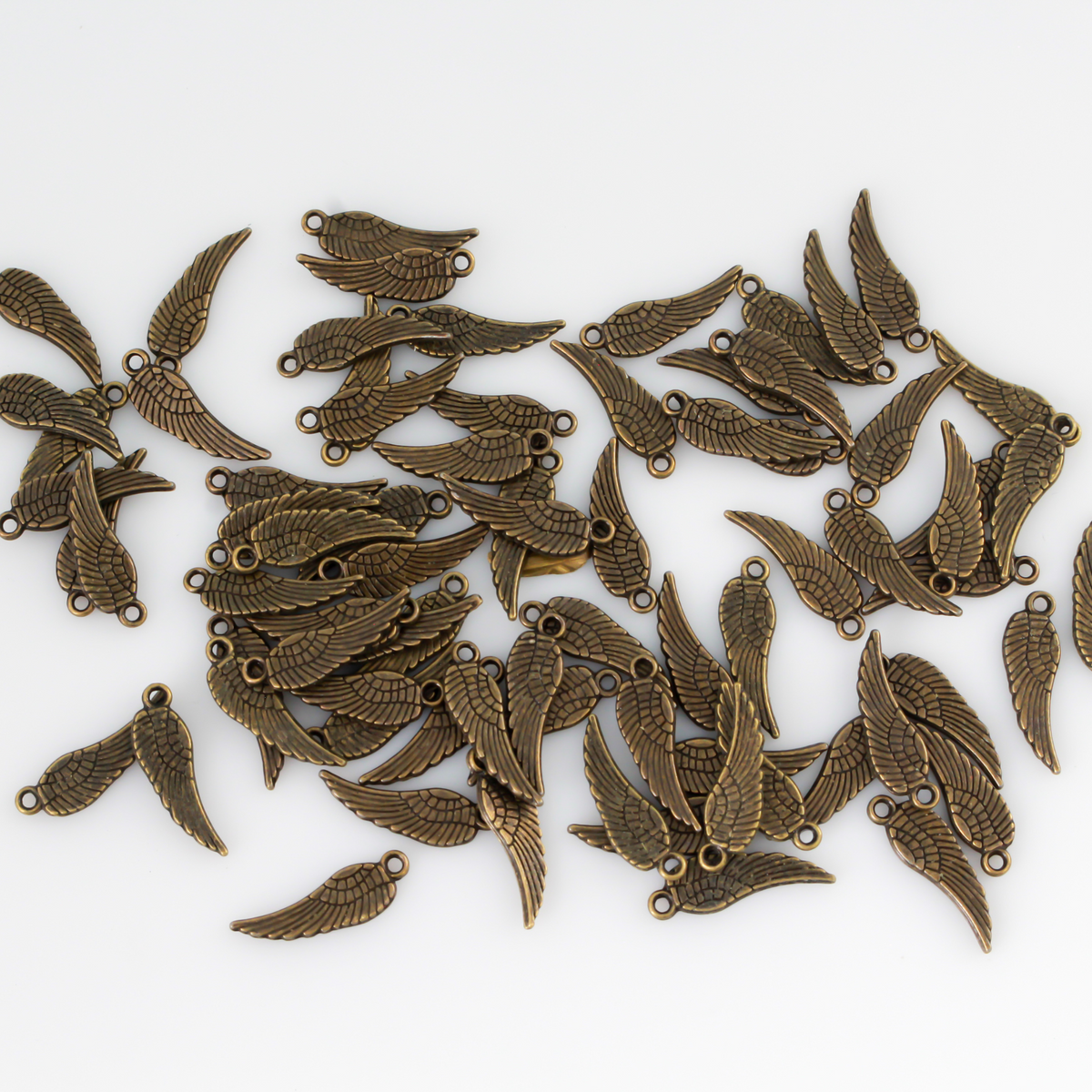 Guardian angel wing charms that are solid and double sided meaning they look the same on the front and back. They are an antiqued bronze color.