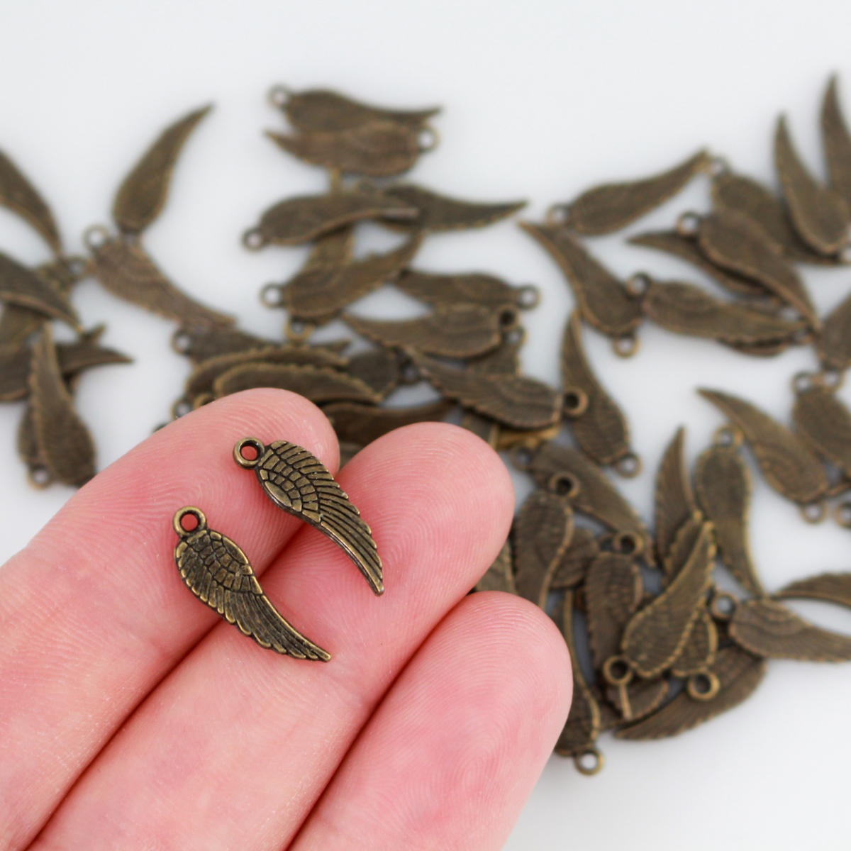 Guardian angel wing charms that are solid and double sided meaning they look the same on the front and back. They are an antiqued bronze color.