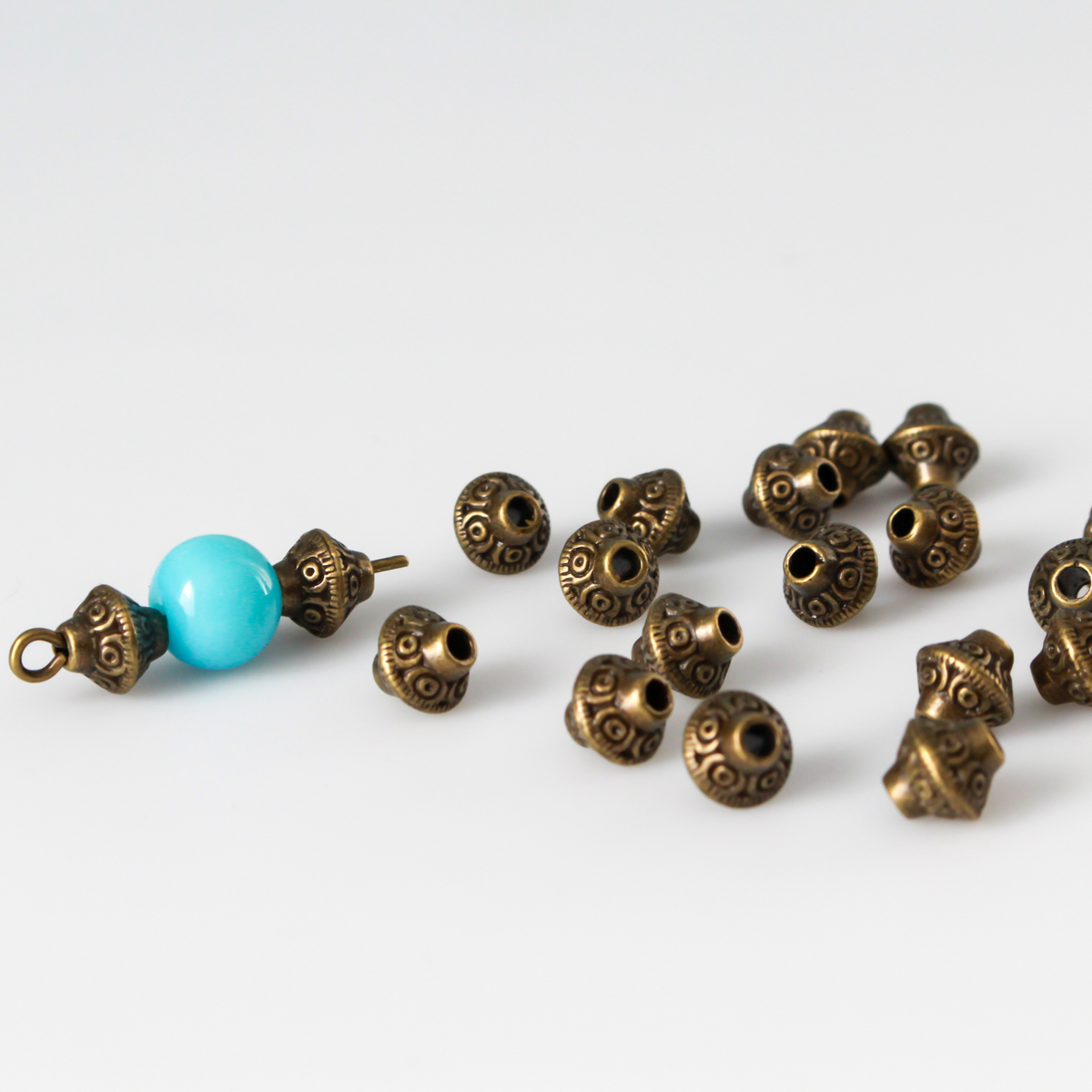 50 metal bicone shaped spacer beads with an antiqued bronze finish and a swirl pattern, 6mm x 6mm