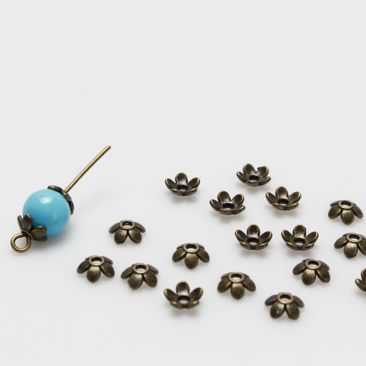 Flower shaped zinc alloy antiqued bronze bead caps that are 6mm in diameter. They can fit beads 6mm - 10mm