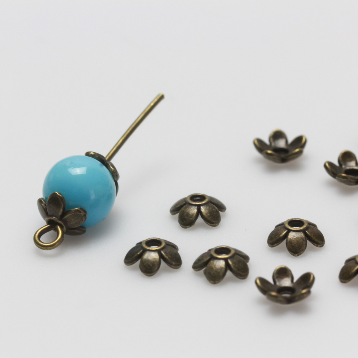 Flower shaped zinc alloy antiqued bronze bead caps that are 6mm in diameter. They can fit beads 6mm - 10mm