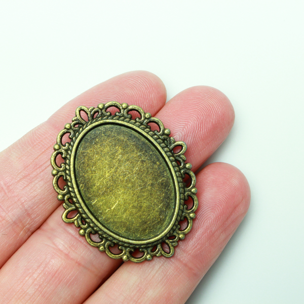 Bronze oval bezel brooch pin with an ornate filigree border. The tray size on this bezel is 25mm x 18mm
