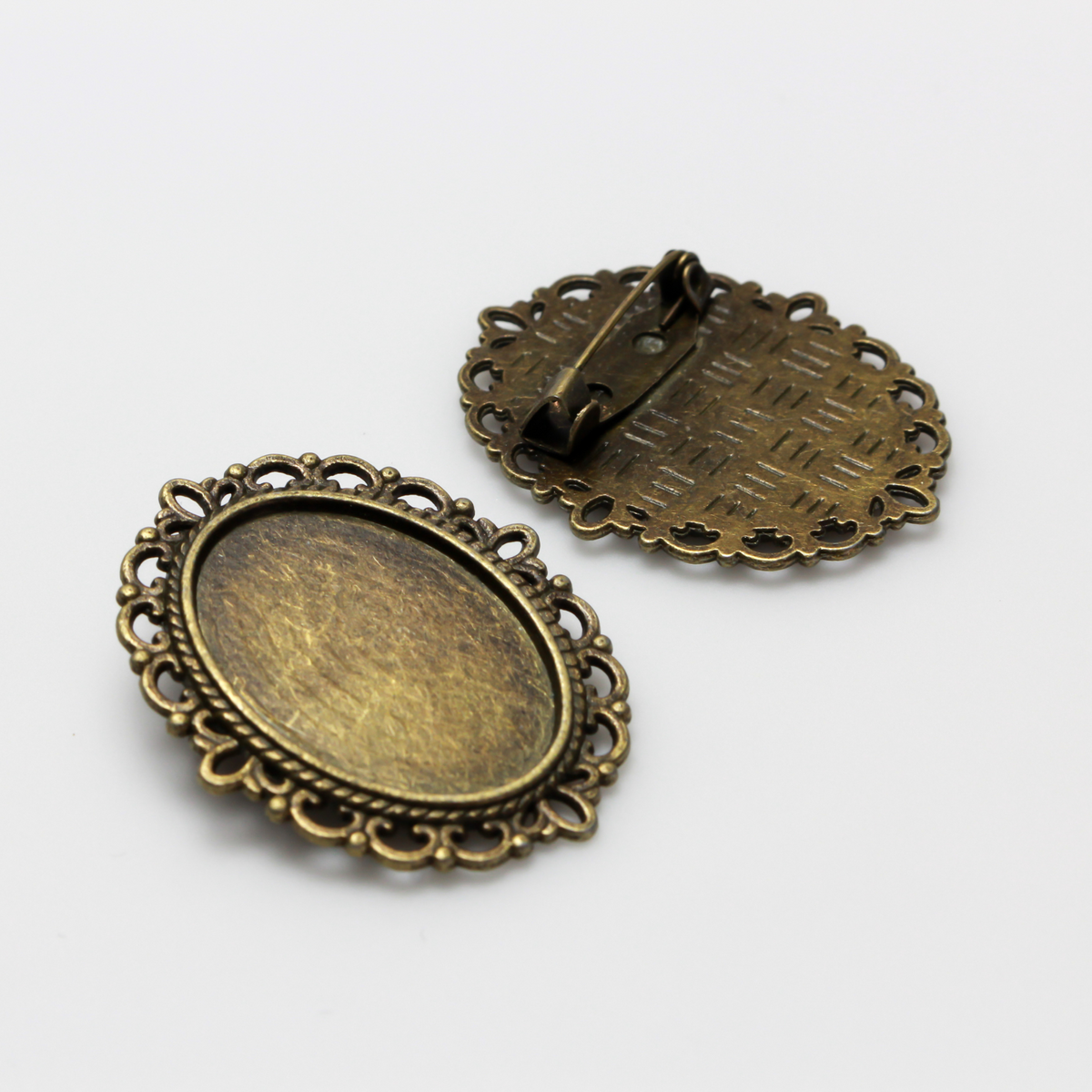 Bronze oval bezel brooch pin with an ornate filigree border. The tray size on this bezel is 25mm x 18mm