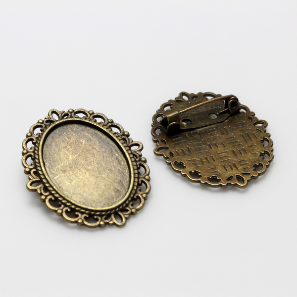 Bronze oval bezel brooch pin with an ornate filigree border. The tray size on this bezel is 25mm x 18mm