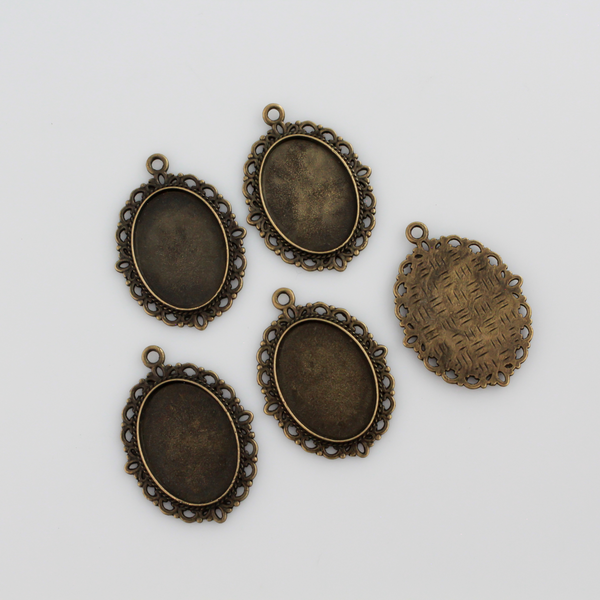 oval pendant cabochon setting in an antiqued bronze color. This is an ornate edge bezel cup with a 25mm x 18mm tray.