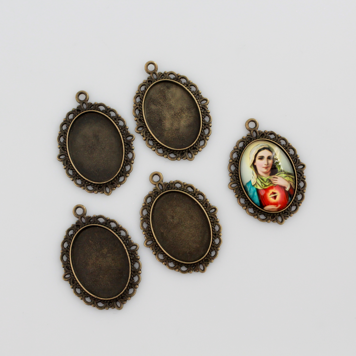 oval pendant cabochon setting in an antiqued bronze color. This is an ornate edge bezel cup with a 25mm x 18mm tray.