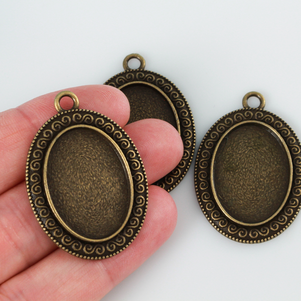 Ornate oval bezel tray setting with an ornate scroll embellished trim