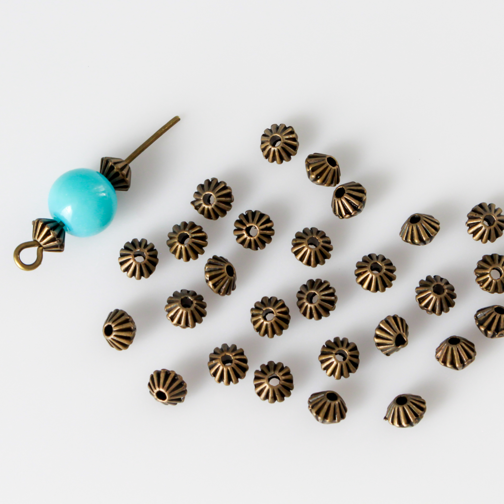 metal bicone shaped spacer beads with an antiqued bronze finish and a corrugated pattern, 5mm x 4mm