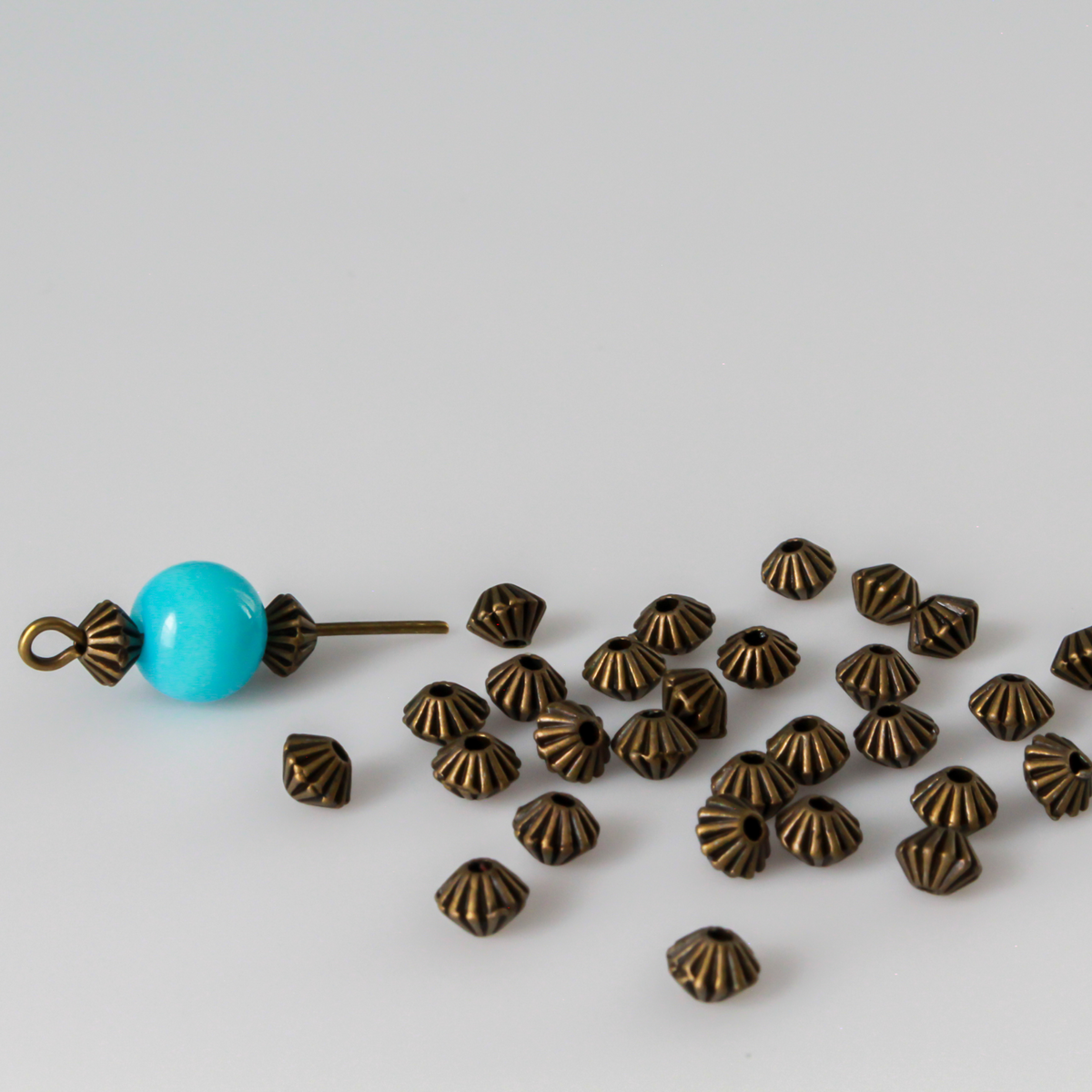 metal bicone shaped spacer beads with an antiqued bronze finish and a corrugated pattern, 5mm x 4mm