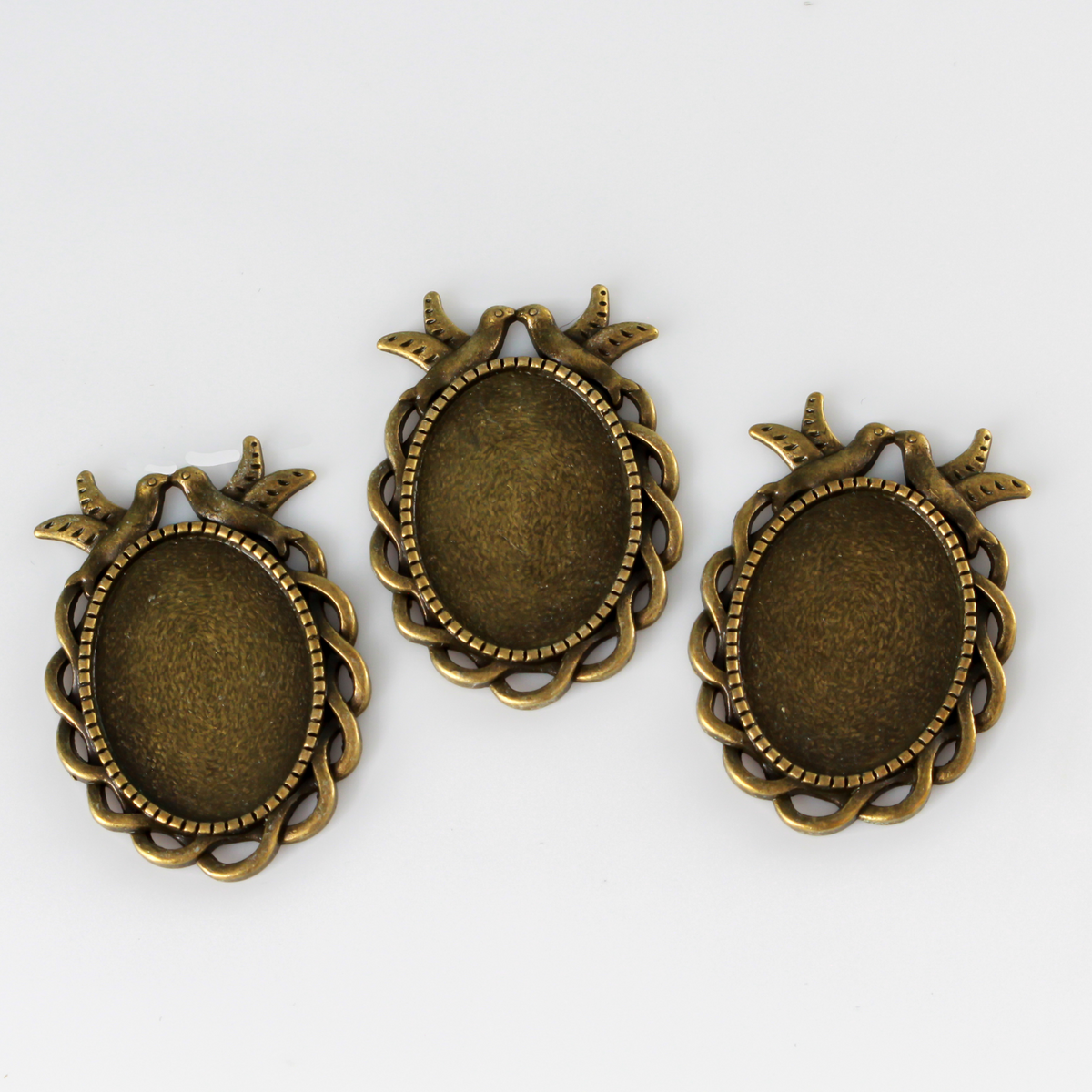 Ornate oval bezel tray setting with an ornate edge and two doves perched at the top