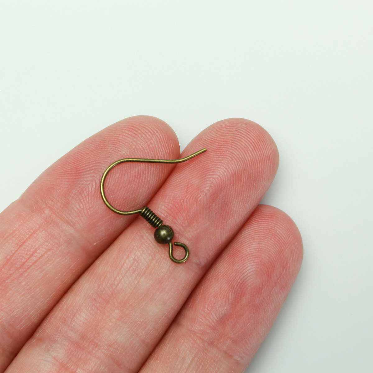 Brass earring hooks with a horizontal loop and an antiqued bronze finish. 23 gauge wire. Sold in packages of 30 hooks (15 pairs).
