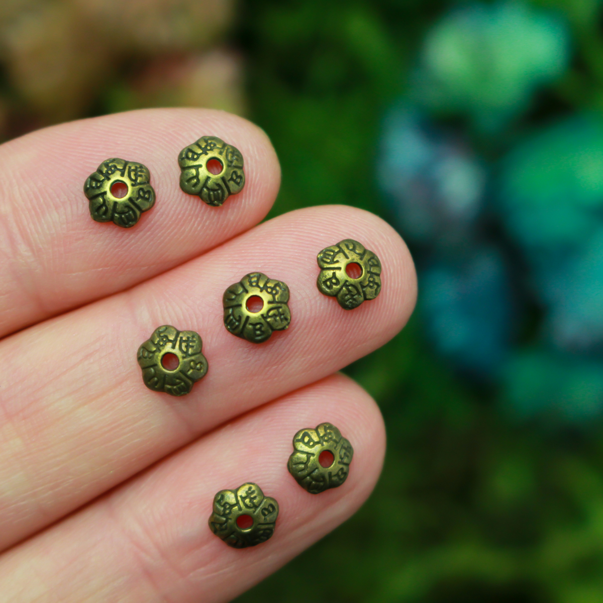 Flower shaped zinc alloy antiqued bronze bead caps that are 6mm in diameter. They can fit beads 6mm - 10mm