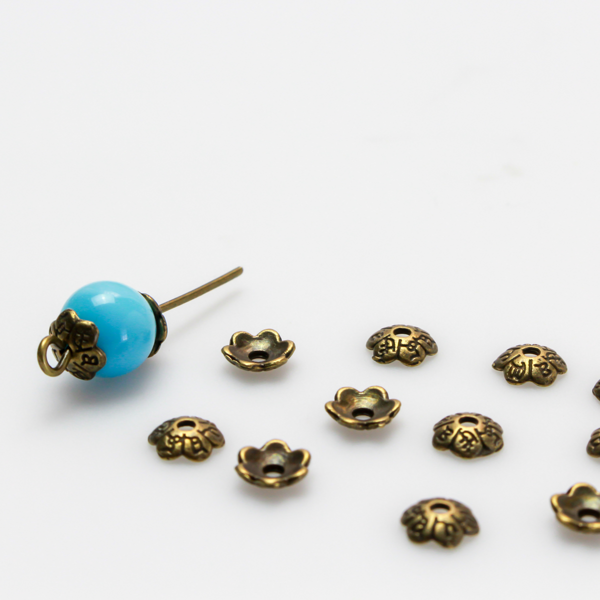 Flower shaped zinc alloy antiqued bronze bead caps that are 6mm in diameter. They can fit beads 6mm - 10mm