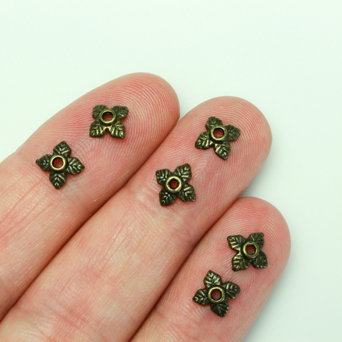 Bronze leaf shaped bead caps with a four leaf pattern, 6mm with a 1mm hole. Sold in packages of 120 pieces.
