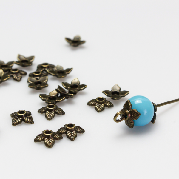 Bronze leaf shaped bead caps with a four leaf pattern, 6mm with a 1mm hole. Sold in packages of 120 pieces.