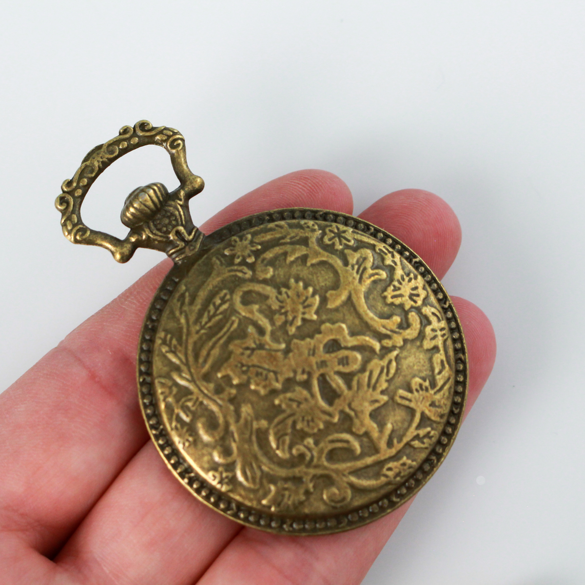 Large bronze cabochon setting shaped like an old ornate pocket watch with a 33mm tray.