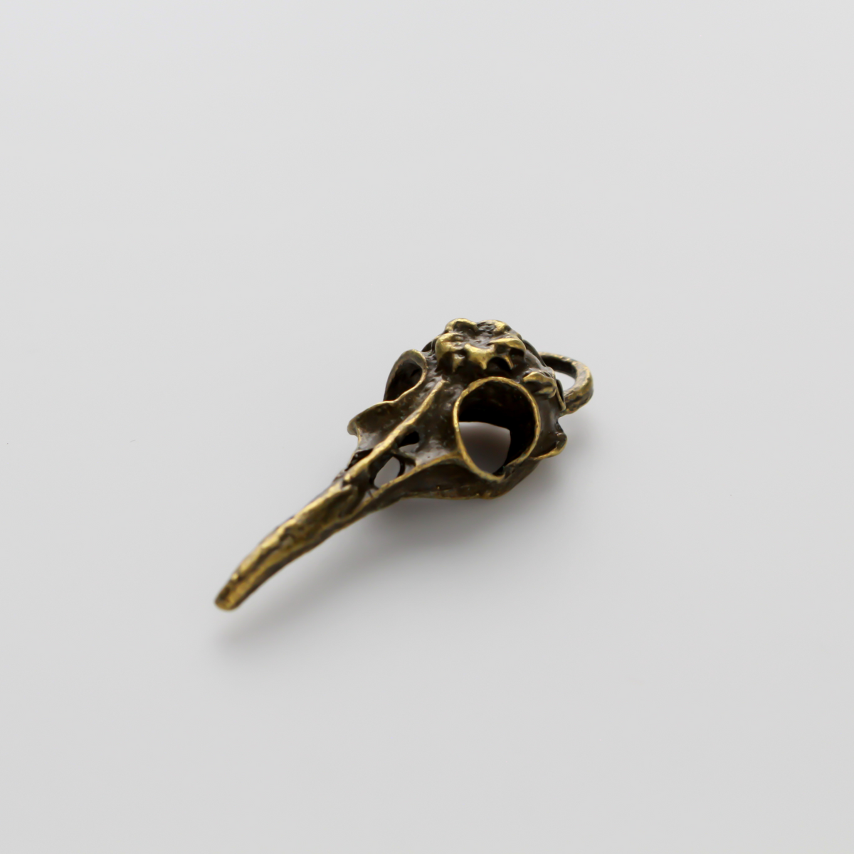 Antiqued bronze tone raven skull charms that have a flower design on the top