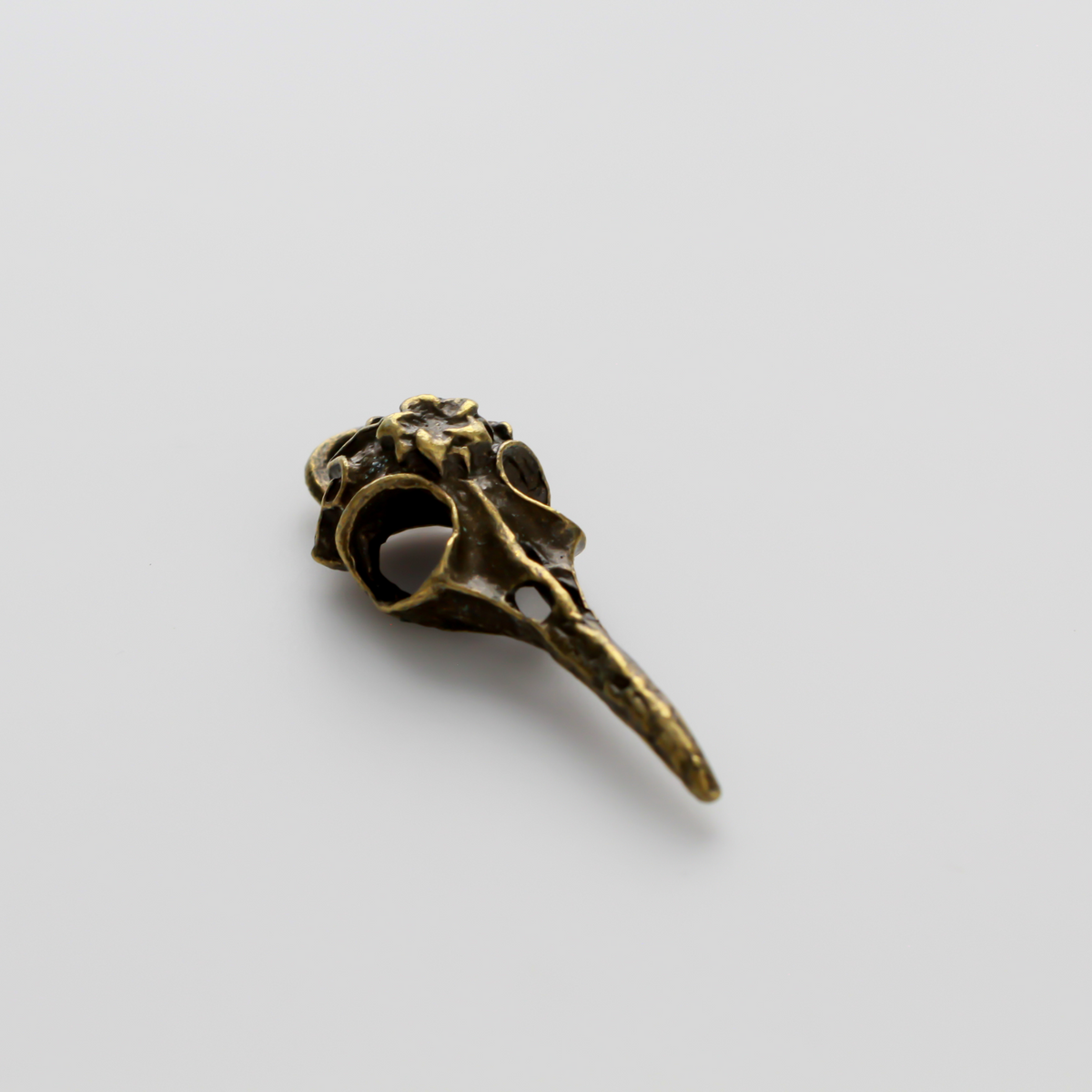 Antiqued bronze tone raven skull charms that have a flower design on the top