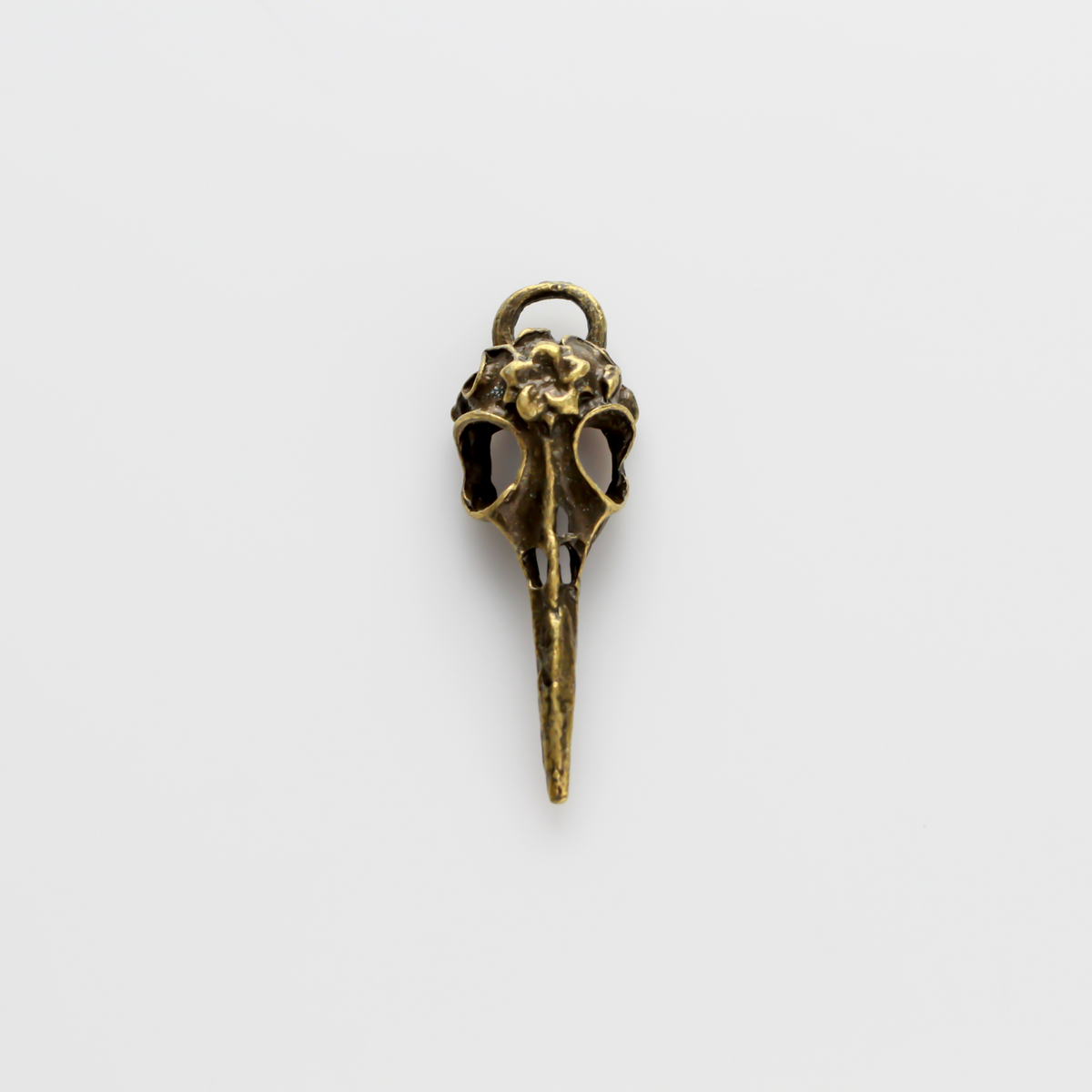 Antiqued bronze tone raven skull charms that have a flower design on the top