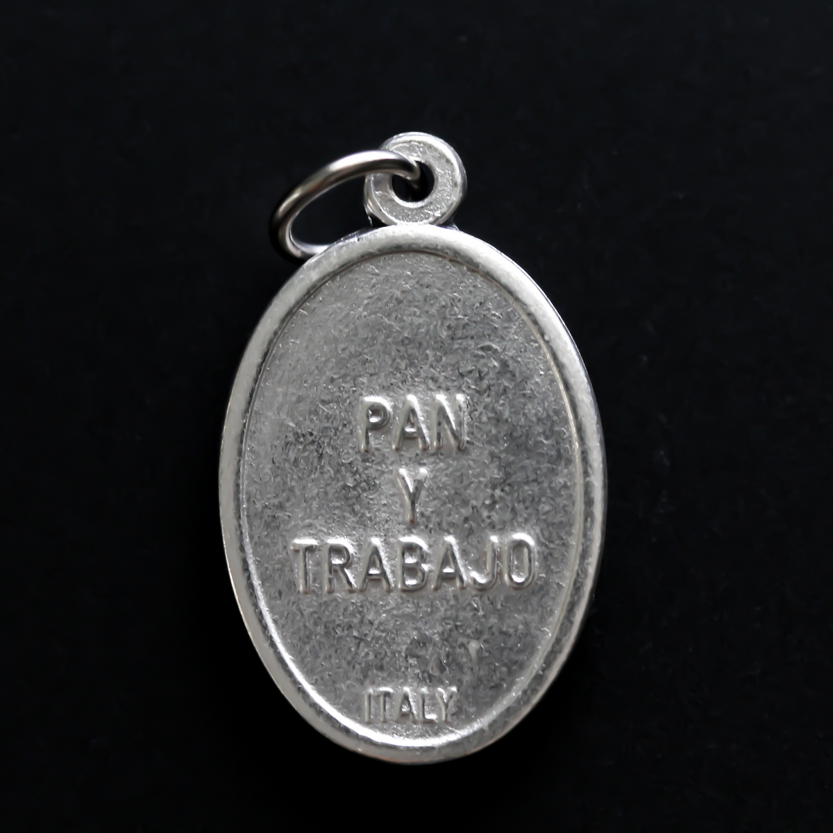 St. Cajetan (Cayetano) oval medal that depicts the saint on the front and "Pan Y Trabajo" on the back which translates from Spanish to "Bread and Labor"