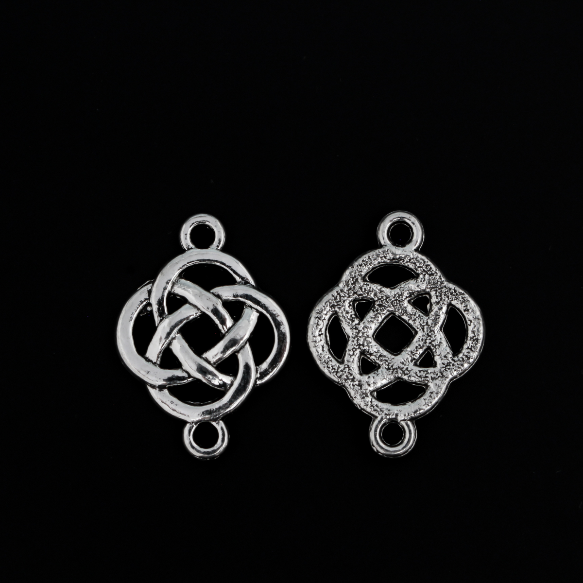 Silver Celtic knot connectors with a filigree cut out design. The backside has a textured pattern, 28x18mm