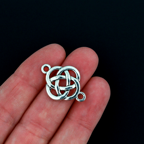 Silver Celtic knot connectors with a filigree cut out design. The backside has a textured pattern, 28x18mm