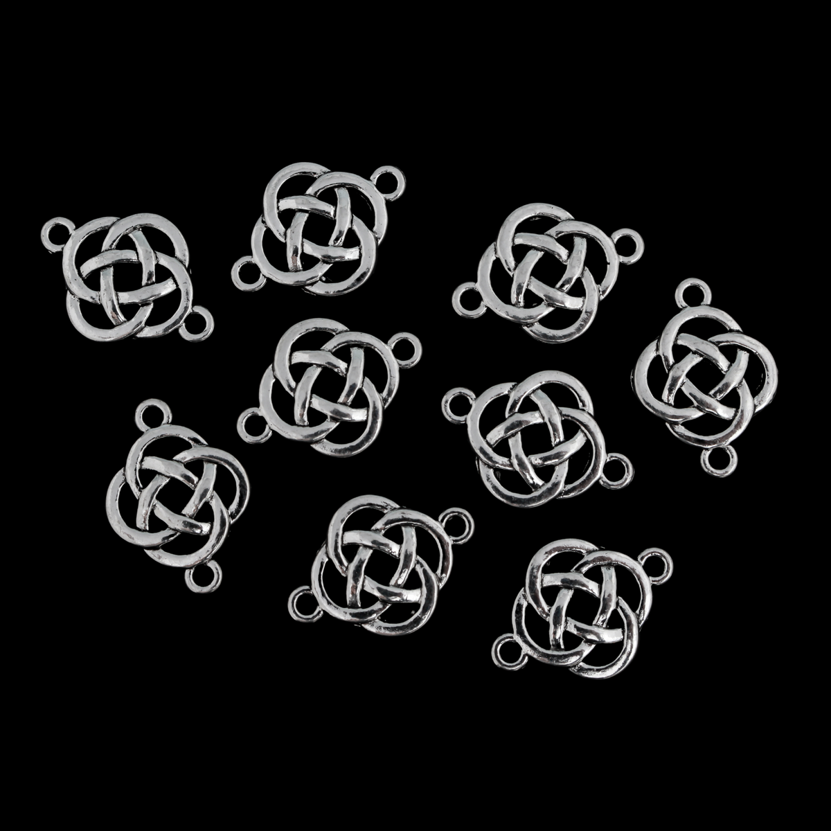 Silver Celtic knot connectors with a filigree cut out design. The backside has a textured pattern, 28x18mm