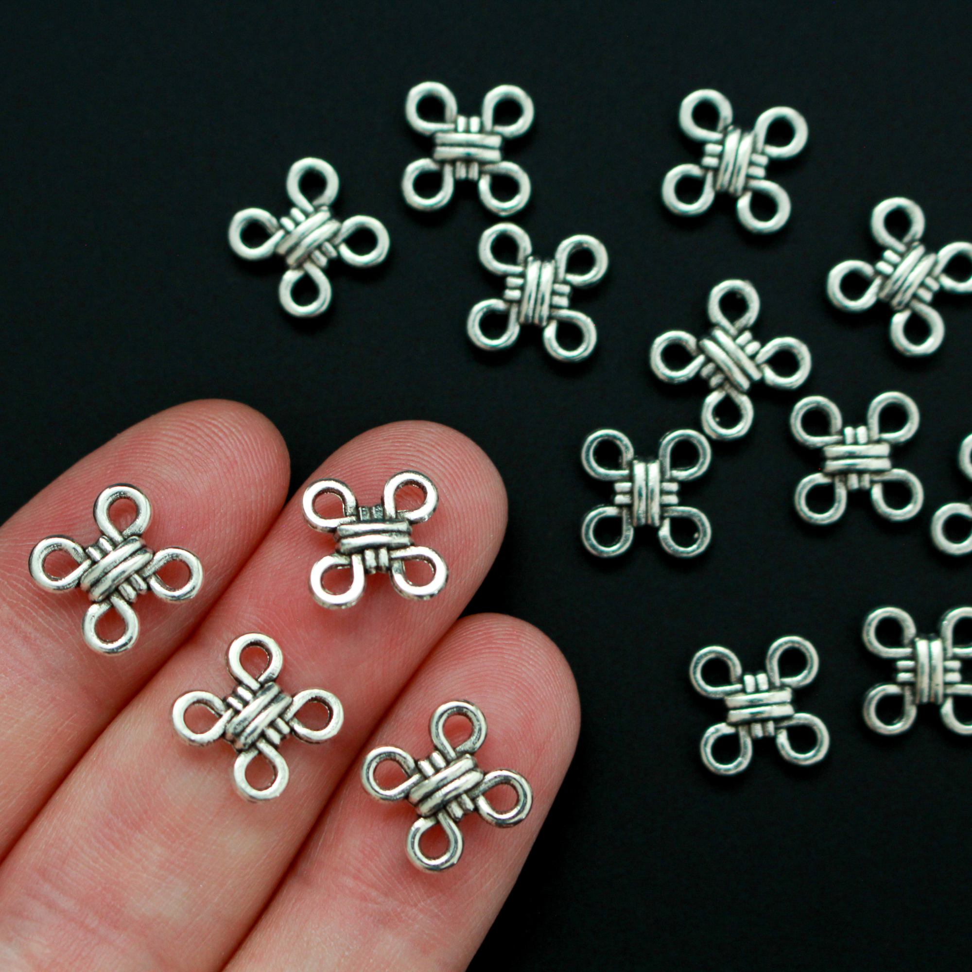 Silver Celtic knot shaped connectors. These are flat connector links with four connectors, one on each corner, 12mm