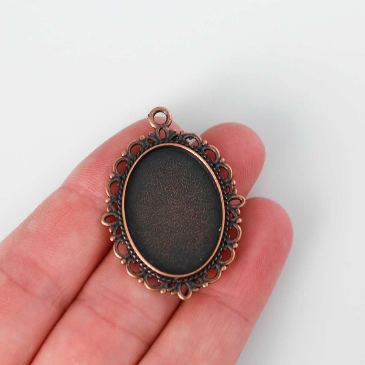 oval pendant cabochon setting in an antiqued red copper color. This is an ornate edge bezel cup with a 25mm x 18mm tray