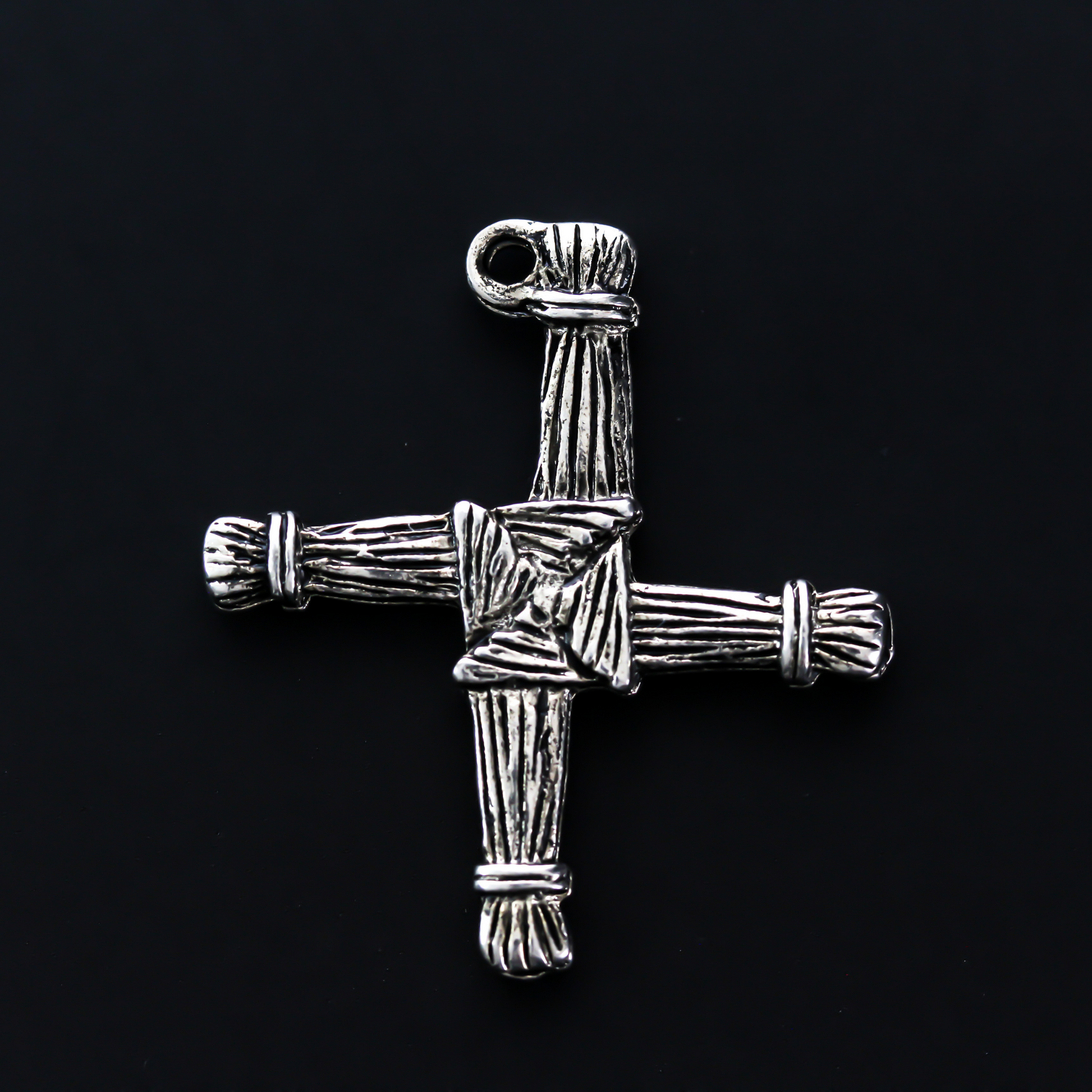 Brigid's cross charm 1-1/8" long The cross is an antiqued silver-tone color and looks the same on both sides. There is no jump ring attached to the bail