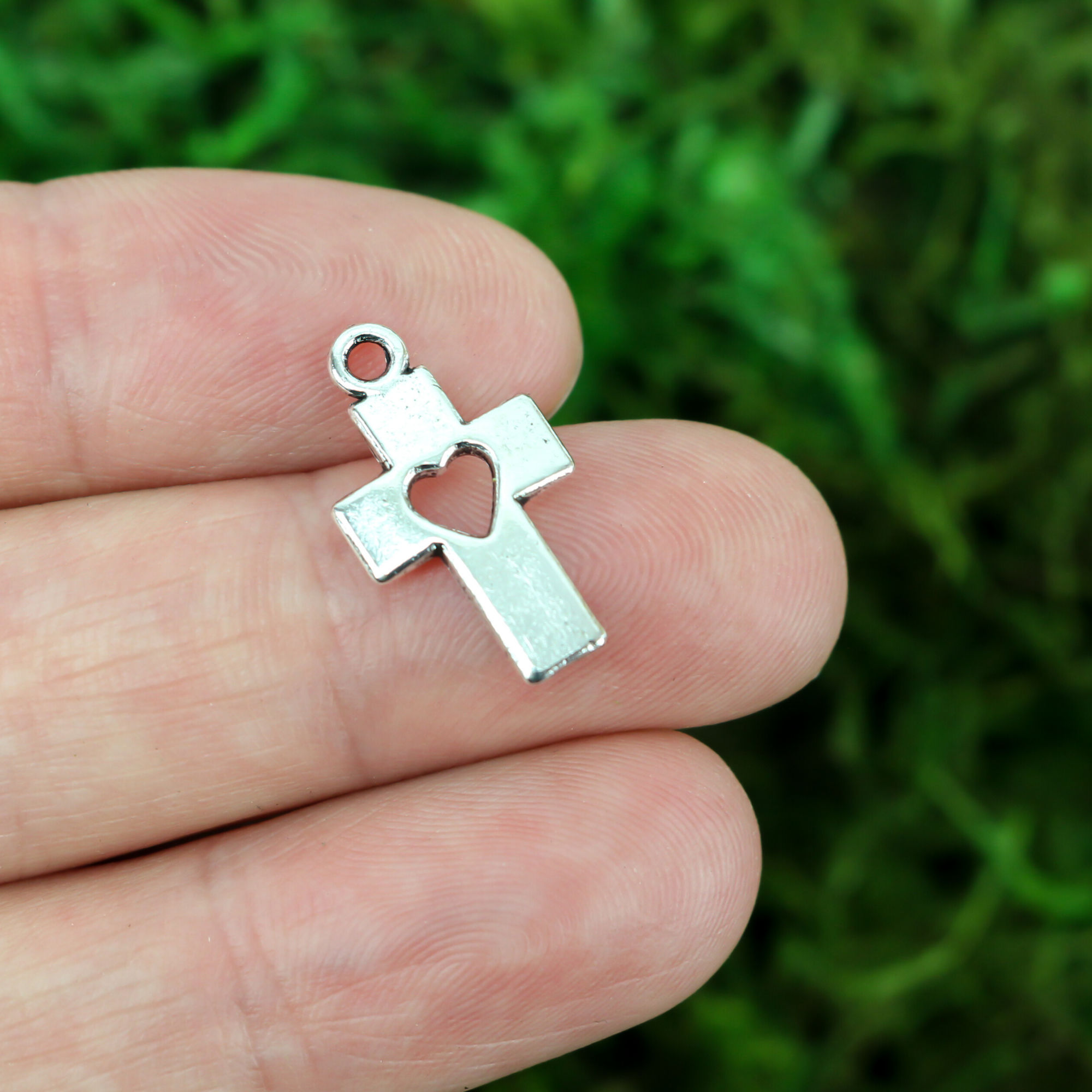 silver tone christian cross charm with cutout heart design