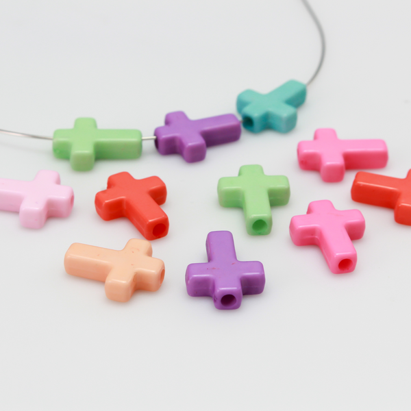 Cross shaped opaque acrylic beads in a random mix of pastel colors.