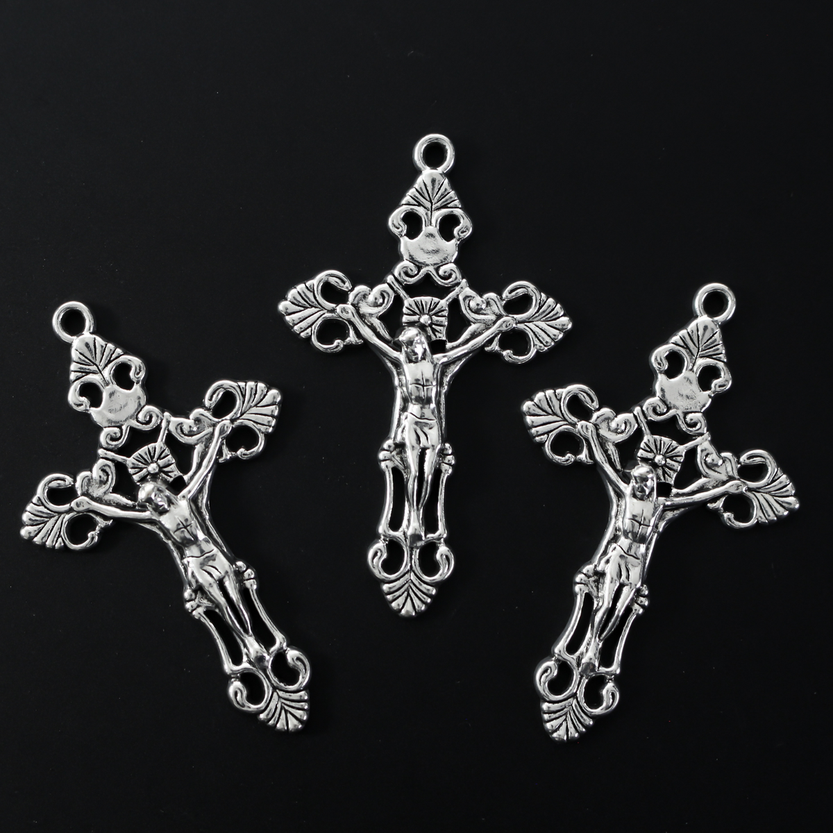 Three ornate fleur de lis crucifix cross in an antiqued silver-tone color and filigree cut out design