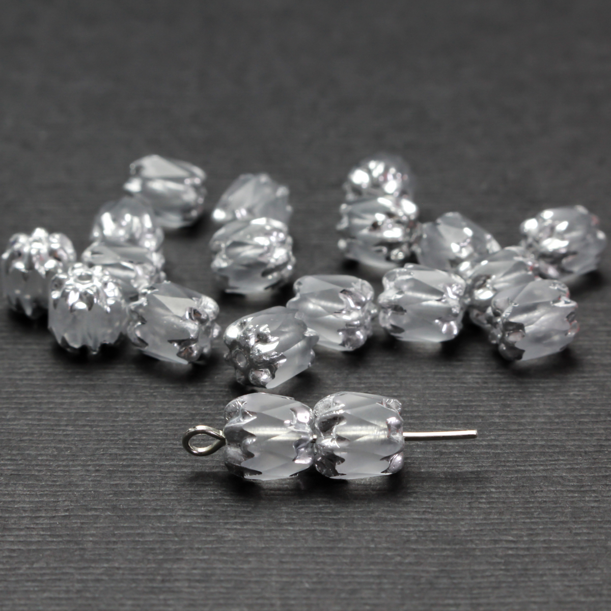 Cathedral shape beads that are clear crystal and faceted. The top and the bottom of the bead are a patterned glass with a silver coating. Made in the Czech Republic. Sold in sets of 20 beads