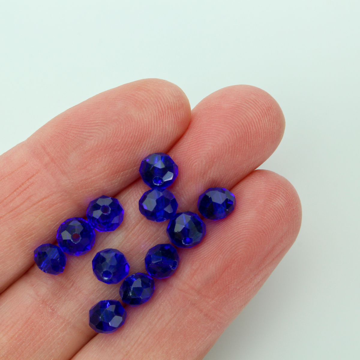 Asian cut crystal glass beads. 6mm x 4mm faceted dark blue transparent. Sold in packages of 60 beads