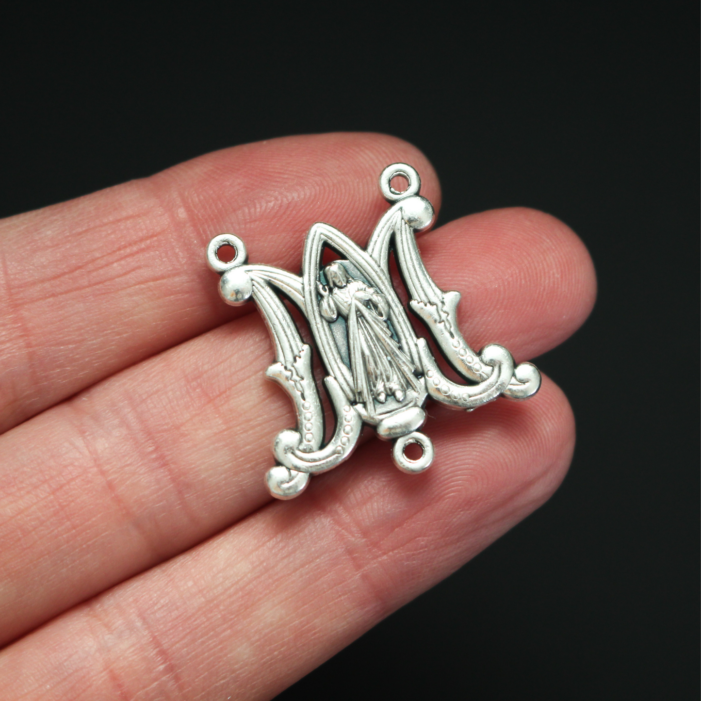 rosary centerpiece in the shape of an intertwined A and M for "Ave Maria" with the Divine Mercy of Jesus in the center