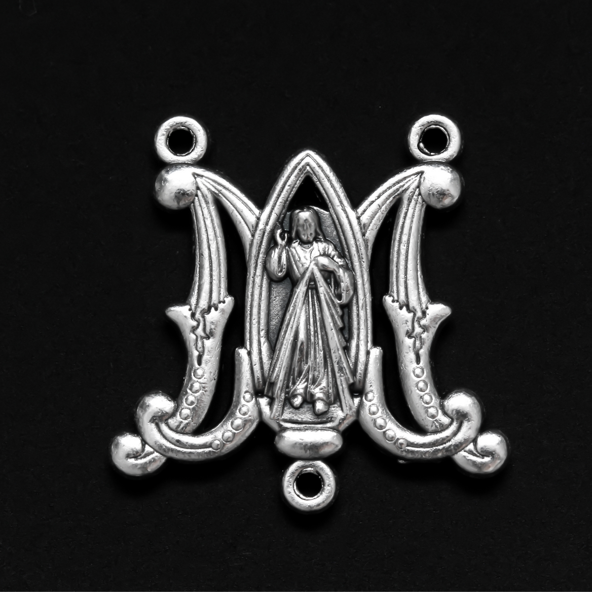 rosary centerpiece in the shape of an intertwined A and M for "Ave Maria" with the Divine Mercy of Jesus in the center